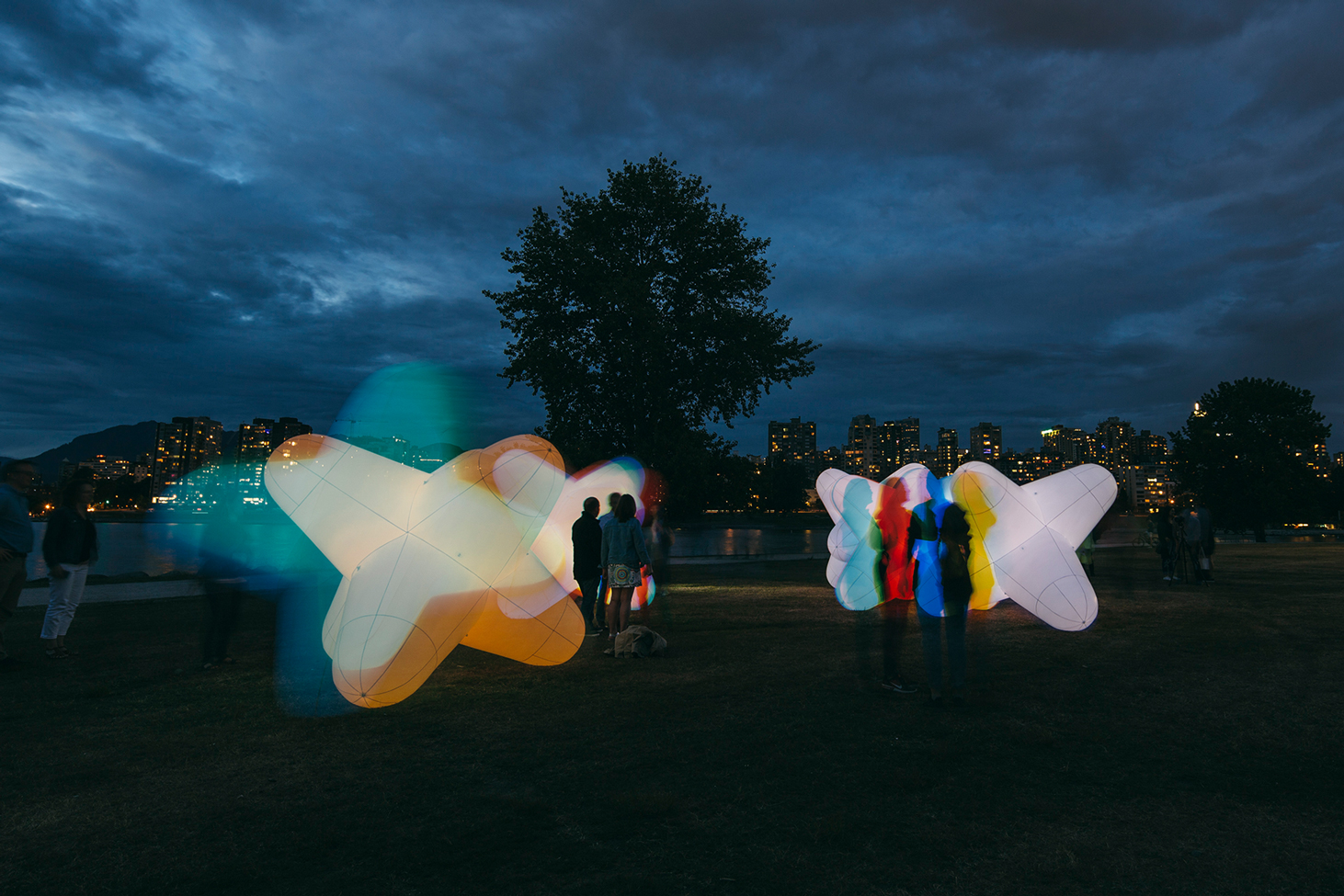 People standing next to 2018 Vancouver Artist Alex Beim's JAX light installation casts interesting shadows.