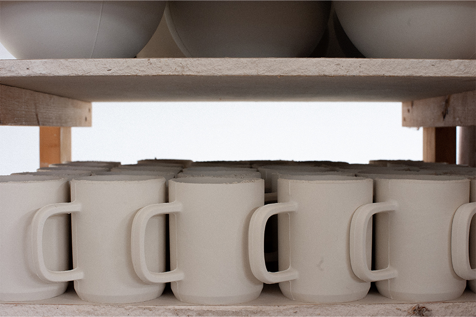 hcma ceramic mugs drying on a shelf before they are ready for firing.