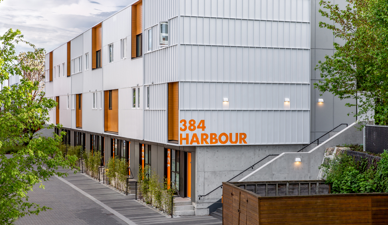 Corner of a white building with orange accents. In large letters, the corner reads "384 HARBOUR"