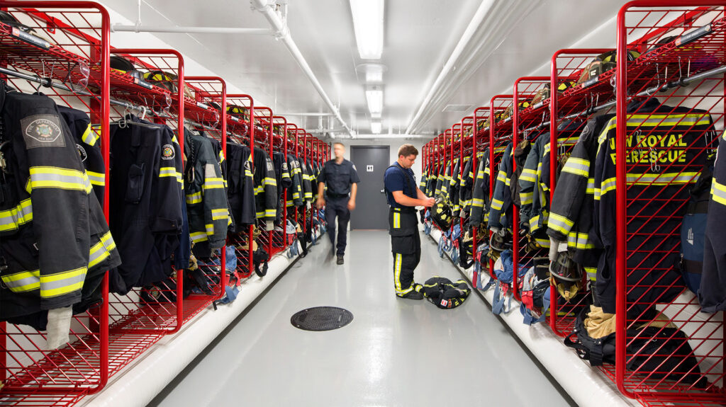 Firefighter gear hung along both sides of a hallway.