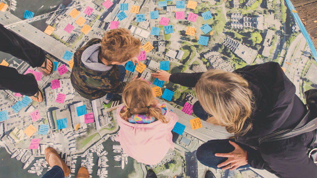 Kids looking at sticky notes stuck all over a Granville Island map