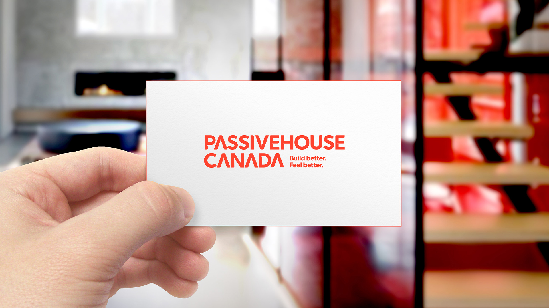 Passive House business card, which is white with red edges and their red logo. 