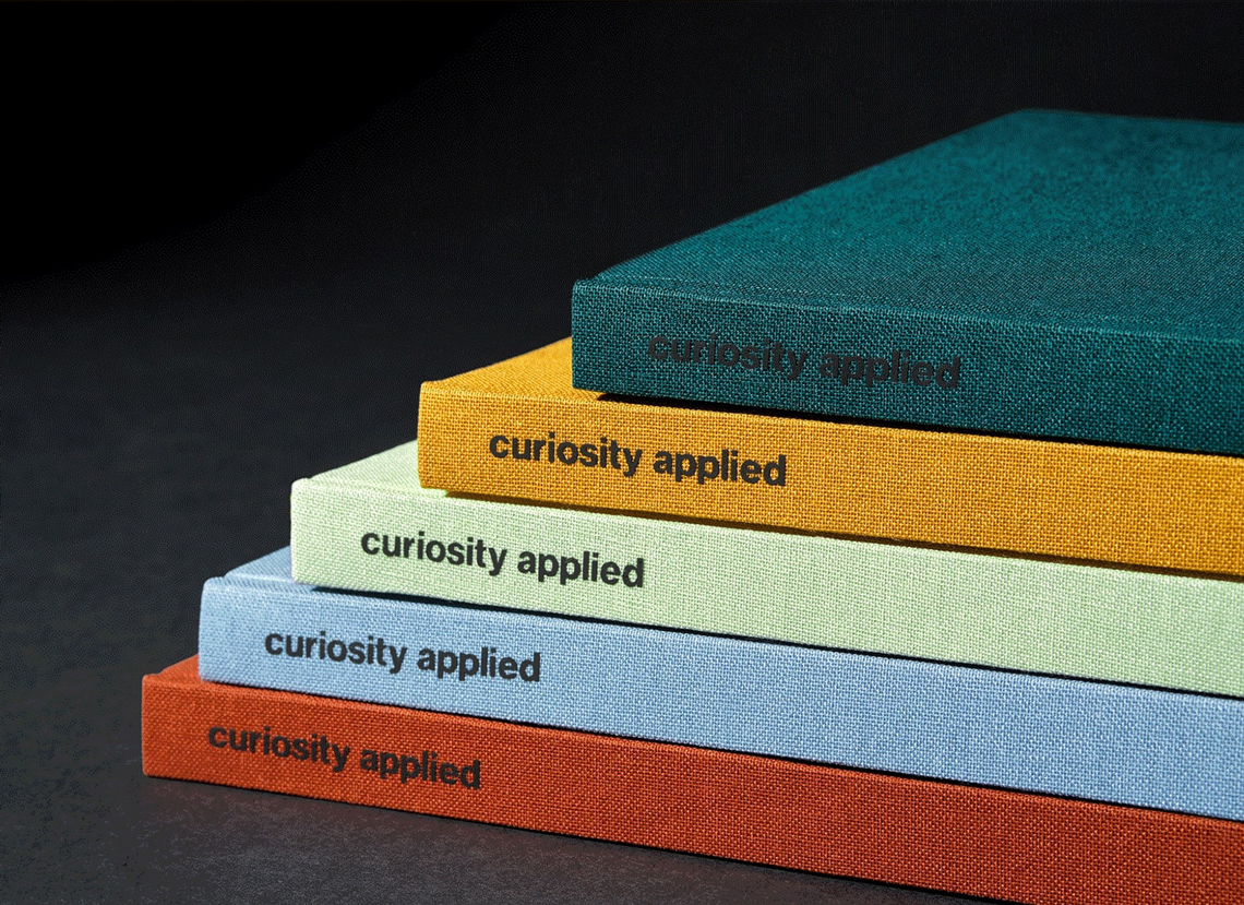 Five HCMA journals diagonally stacked. Each one is a different colour. 