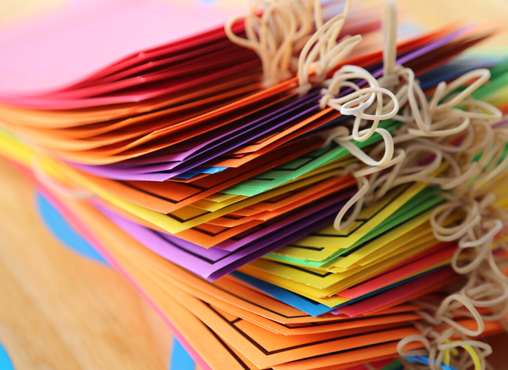 Colourful paper cards stacked on top of each other, tied together with string.