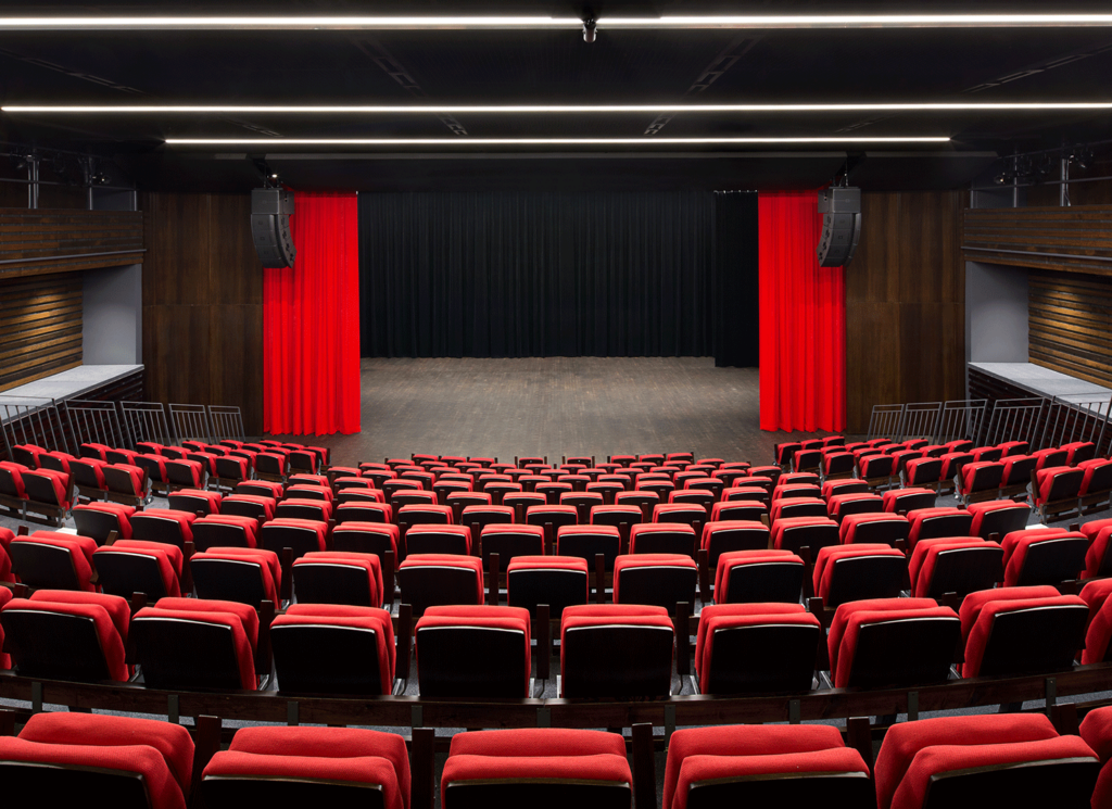 Theatre with red seats and red curtains.
