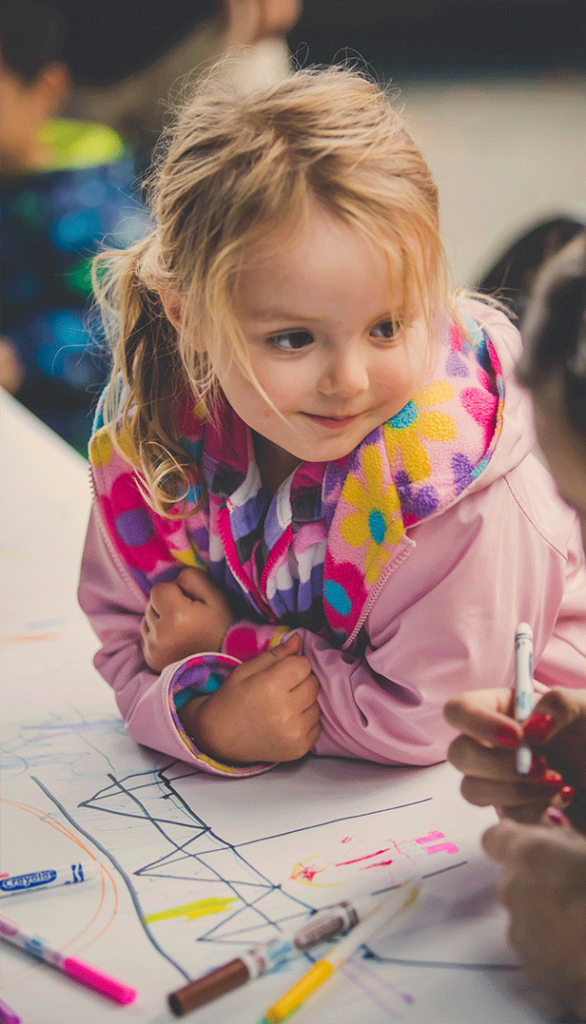 Little girl smiling while colouring