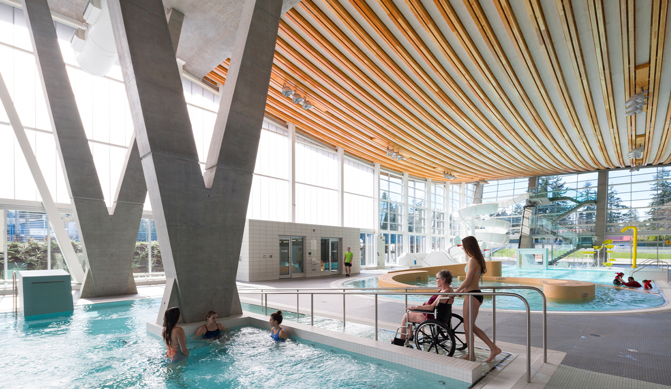 The ramp at Grandview Heights Aquatic Centre in Surrey BC provides a safe way for persons with mobility aids, or limited mobility, to enter the pool. (Rick Hansen Foundation Accessibility Certified project) Photo credit: Hubert Kang