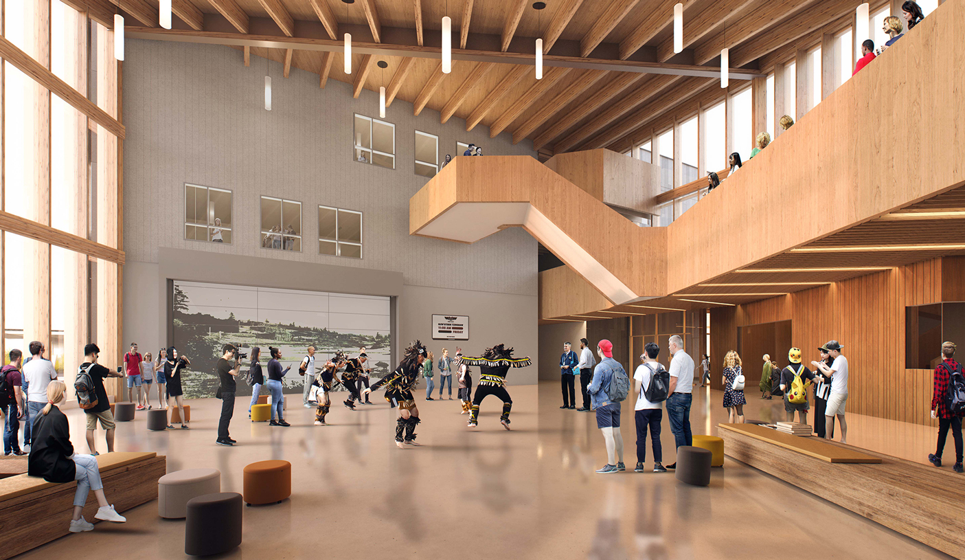 The central multipurpose space, with a mass timber roof and wood interior. Students gathering in the centre, watching an Indigenous dance.