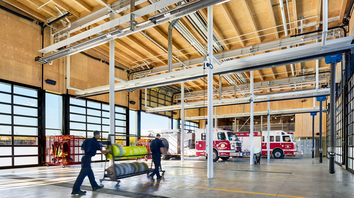 Garage with firetrucks and a wooden ceiling.