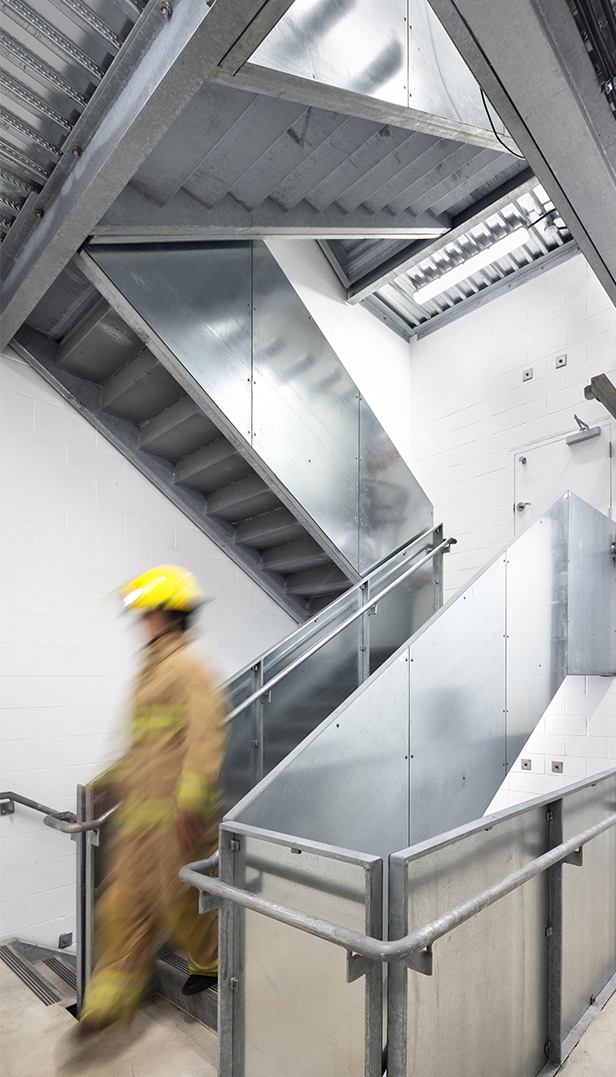 A Firefighter walking down a flight of metal stairs.