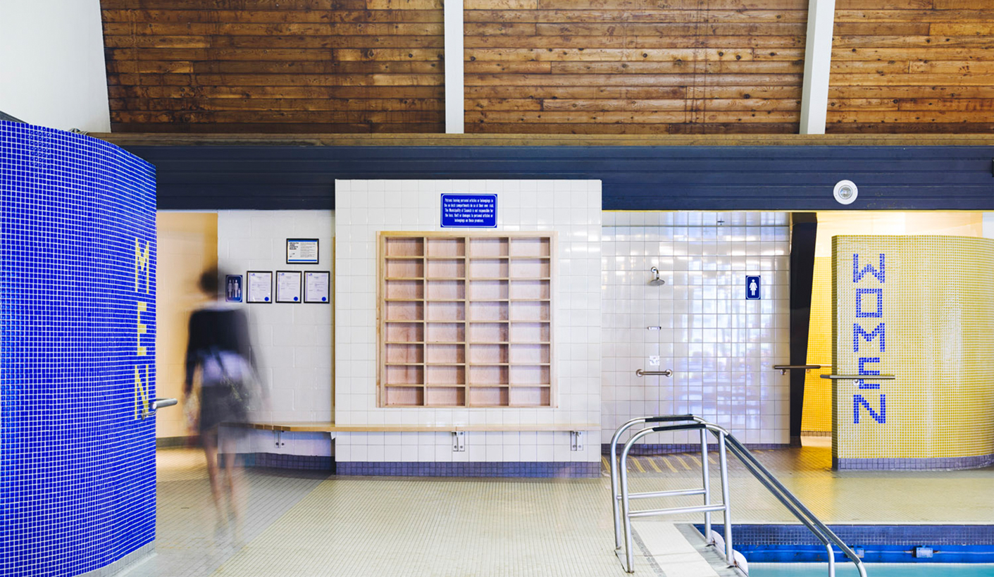 A view of the entrance into the washrooms from the indoor pool deck at Gordon Head Recreation Centre features bright blue and yellow tiles.