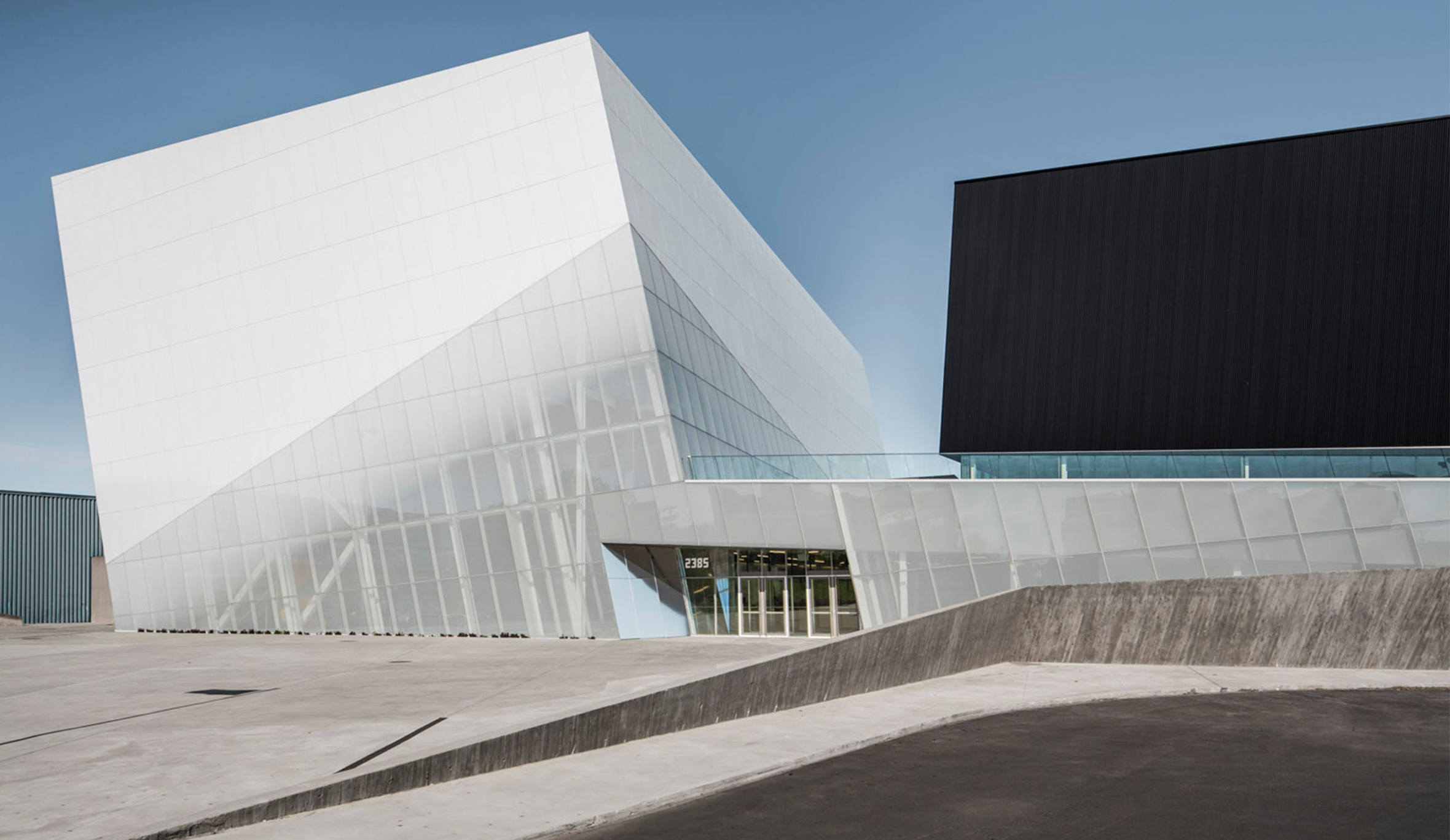 Strong angular shapes of the black and white volumes that form the Saint Laurent Sports Complex.