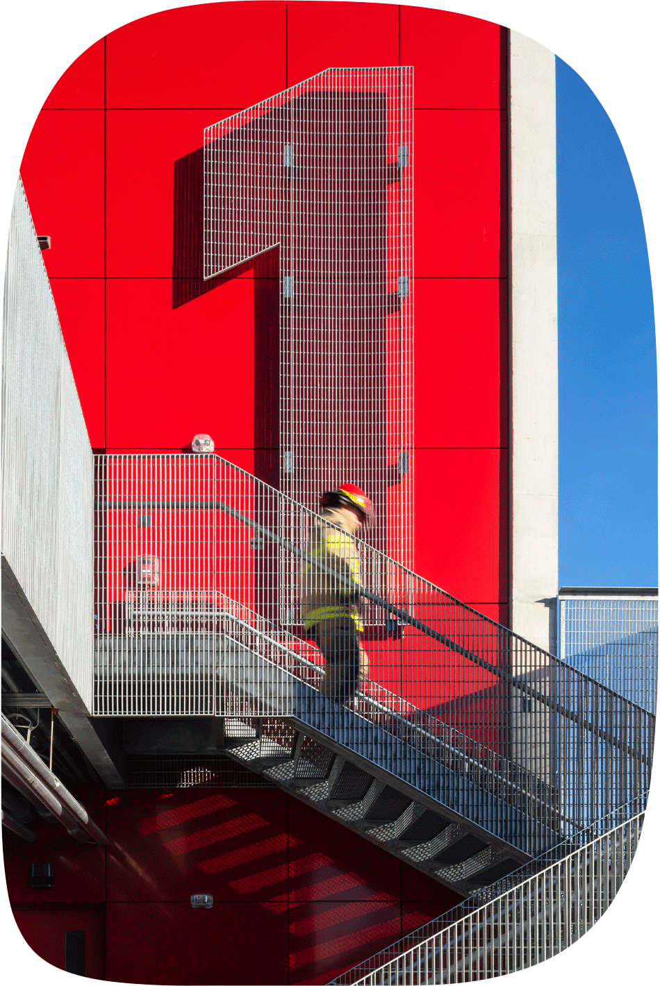 Exterior shot of a firefighter walking down the stairs with the firehall number signage prominently behind him