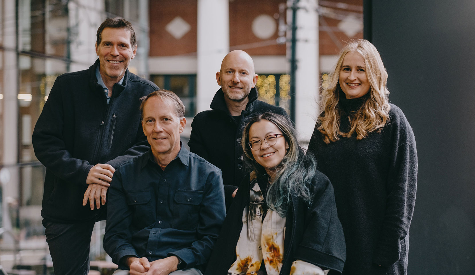 Dan, Michael, Kim, Adam, and Rance in a group photo at Waterfront Station. Dan, Michael, and Kim are standing while Adam and Rance are seated in front of them.