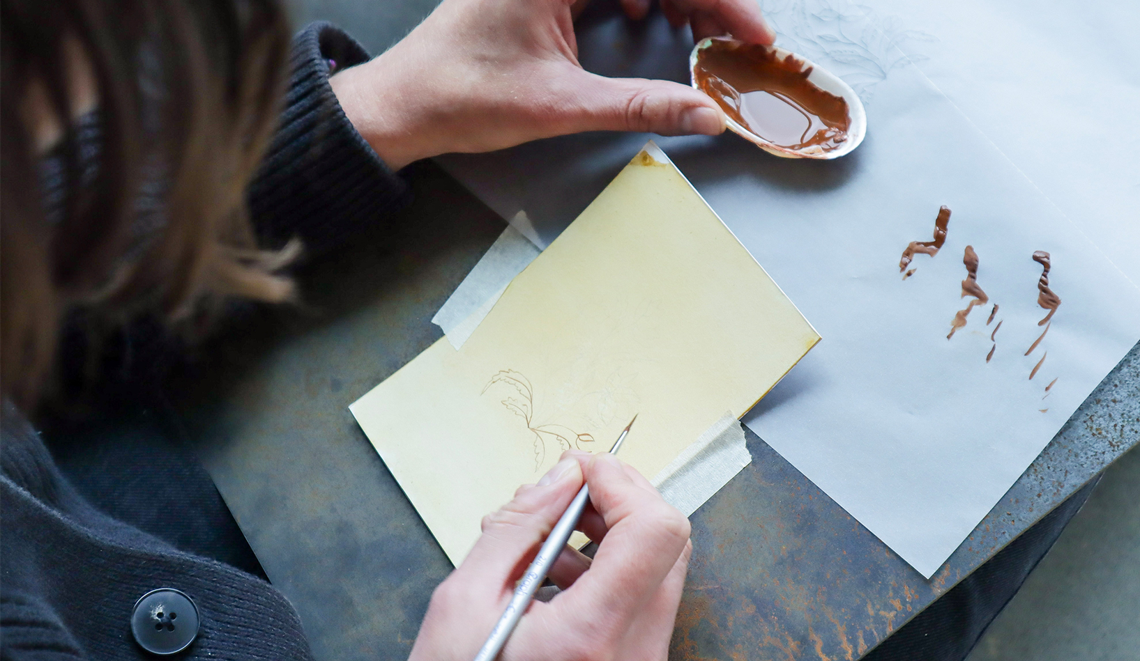 Photo taken over the shoulder of an hcma-er trying out Persian miniature painting, during Heraa Khan's workshop in the Edmonton office.